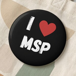 Botão "Eu Amo MSP": Fundo preto, coração vermelho, texto branco com efeito desgastado.