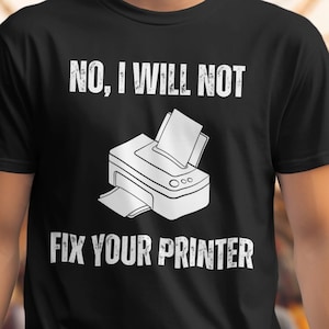 Könnte beinhalten: Schwarzes T-Shirt mit weißem Text, der "NEIN, ICH WERDE DEINEN DRUCKER NICHT REPARIEREN" lautet, und einer weißen Illustration eines Druckers.