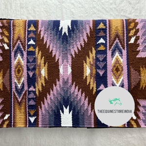 Könnte beinhalten: Ein braunes, violettes und goldenes Sattelpad mit einem weißen geometrischen Muster. Das Sattelpad trägt den Text "THEEQUINESTOREINDIA" auf einem weißen Kreis.