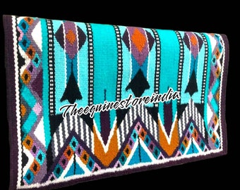 May include: A turquoise, purple, orange, black and white saddle pad with a geometric pattern. The saddle pad has a purple border and the text "Theequinestorerindia" is printed in the centre.