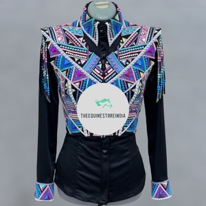 Könnte beinhalten: Ein schwarzes Langarm-Showhemd mit einem farbenfrohen geometrischen Design auf der Vorderseite. Das Design ist mit rosa, blauen und weißen Strasssteinen und Perlen verziert. Das Hemd hat einen Knopfleisten vorne und eine figurbetonte Silhouette.