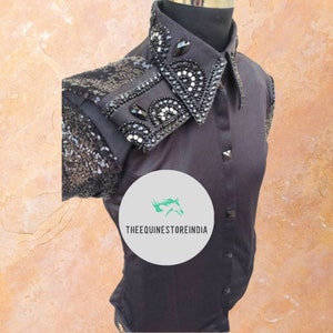 May include: Black short-sleeved shirt with a sequined shoulder and a large embellished collar. The collar features black and white rhinestones and a black horse head logo with the text "THEEQUINESTOREINDIA".
