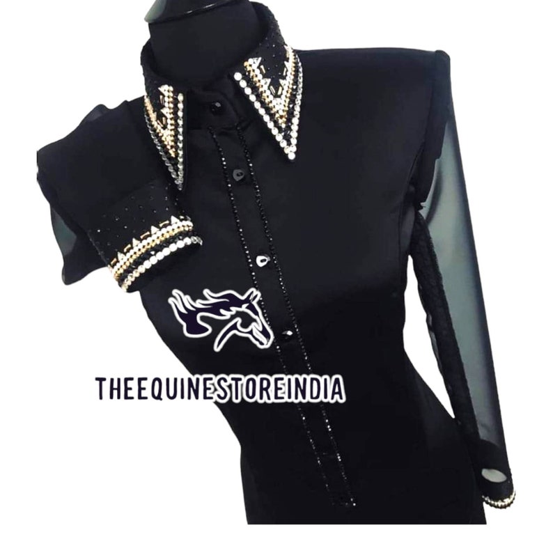 Pu&ograve; includere: Camicia nera a maniche lunghe con un polsino in rete trasparente. La camicia ha un grande colletto decorato con strass e dettagli dorati. La camicia ha anche un design di strass sui polsini. La camicia ha un logo di cavallo sul davanti con il testo "THEEQUINESTOREINDIA".