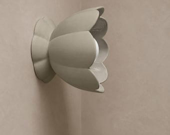 May include: A wall-mounted light fixture shaped like a blooming flower with six large, curved, matte beige petals. The fixture is attached to a matching beige circular base and features a single white light bulb visible within the center of the petals.