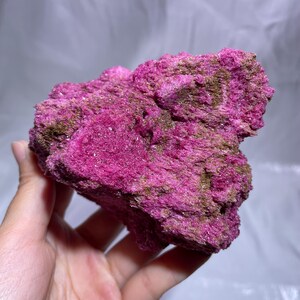 May include: A vibrant, raw mineral specimen featuring a striking combination of deep magenta and earthy brown hues. The crystalline structure is visible, creating a textured appearance. This natural stone is a unique addition to any collection.