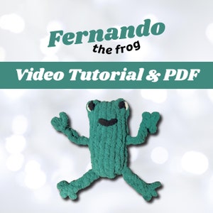 May include: A green knitted frog named Fernando, with white eyes and a black smile. The image includes the text "Fernando the frog" and "Video Tutorial & PDF".