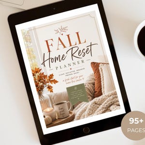 May include: A digital tablet displaying a Fall Home Reset Planner cover page with text, featuring a cozy scene of a mug, candle, and autumn leaves. The screen shows the title Fall Home Reset Planner, clean declutter organize prepare enjoy, and a 95+ pages badge.