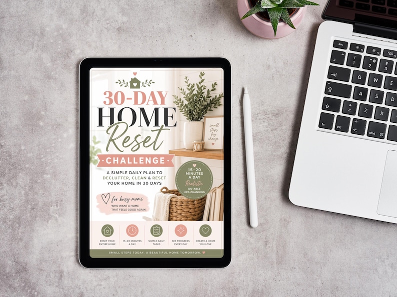 May include: A digital tablet displaying a 30-Day Home Reset Challenge guide. The screen features text, a house icon, a woven basket, and a plant. The layout includes a daily plan, a 15-20 minutes a day badge, and five circular icons at the bottom.