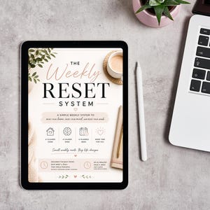 May include: A digital tablet displaying a document titled The Weekly Reset System, featuring a clean layout with icons for home, mind, and planning. The screen includes text about weekly resets, busy schedules, and time management, presented in a soft, neutral color palette with botanical accents.