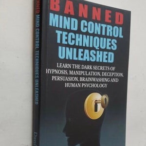 Może przedstawiać: Czarna książka z tytułem "Banned Mind Control Techniques Unleashed" w kolorze czerwonym i niebieskim. Okładka książki przedstawia sylwetkę ludzkiej głowy z dziurką od klucza na czole. Podtytuł książki brzmi: "Poznaj mroczne sekrety hipnozy, manipulacji, oszustwa, perswazji, prania mózgu i psychologii człowieka".