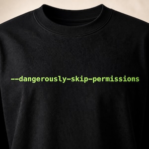 以下が含まれることがあります： 胸元に明るいライムグリーンの文字で「--dangerously-skip-permissions」とプリントされた黒の長袖シャツ。この衣類は、クラシックなクルーネックラインと、シンプルで無地の黒い生地の構造が特徴です。