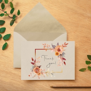 Puede incluir: Una tarjeta de agradecimiento con un dise&ntilde;o floral de acuarela en tonos naranja, rosa y marr&oacute;n. Las flores est&aacute;n dispuestas en un marco cuadrado con un borde dorado. El texto "&iexcl;Gracias!" est&aacute; escrito en cursiva negra.