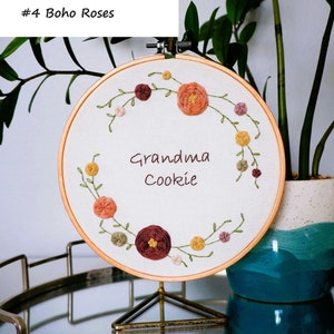 Puede incluir: Arte de bordado en aro con una corona de flores y hojas coloridas, con el texto "Grandma Cookie" en el centro.