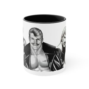 May include: White ceramic mug with a black interior rim. The mug features a black and white illustration of three men, one wearing a leather jacket. The mug is a standard 325 ml size.