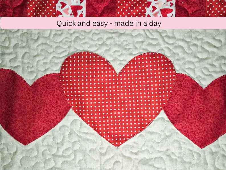 May include: A quilted textile featuring three red hearts on a white background. The central heart has a white polka dot pattern. The text "Quick and easy - made in a day" is displayed above the hearts.