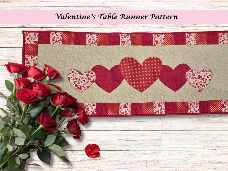 May include: A Valentine's Day table runner with a beige center and red borders. The runner features five heart appliqu&eacute;s in varying red patterns. A bouquet of red roses is in the foreground. The text "Valentine's Table Runner Pattern" is at the top.