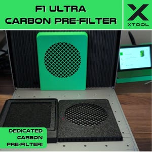 May include: A green 3D printed pre-filter for an F1 Ultra 3D printer. The pre-filter has a black carbon filter inside. The text "F1 Ultra Carbon Pre-Filter" is at the top of the image. The text "Dedicated Carbon Pre-Filter!" is at the bottom of the image. The text "XTOOL" is in the upper right corner of the image.