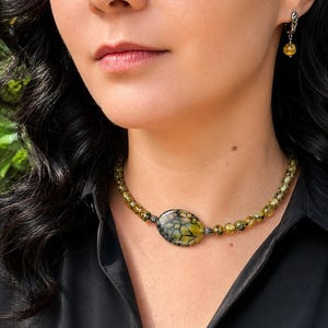 Halsband med gulgrönt drake-ven-agat, armband med minnestråd, örhängen i sten