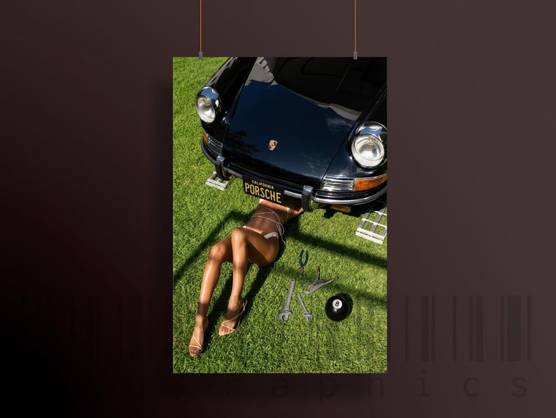 May include: A black Porsche sports car with a California license plate that reads "PORSCHE" is being worked on by someone lying on the grass. Tools and a black 8-ball are scattered on the green lawn.