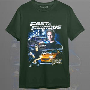 May include: Forest green t-shirt featuring the text "Fast & Furious" with images of cars and Paul Walker. The shirt has a crew neck and short sleeves. The brand name "Magnum" is printed on the shirt.