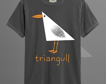 May include: A graphite-colored short-sleeve t-shirt featuring a graphic of a white triangular bird with an orange beak and legs. The text "triangull" is printed in orange below the bird. The shirt has a crew neckline and a visible brand label.