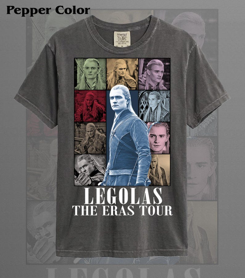 May include: Pepper color t-shirt featuring a collage of images of Legolas from The Lord of the Rings. The design includes the text "LEGOLAS THE ERAS TOUR" in white block letters. The shirt has a crew neck and short sleeves.