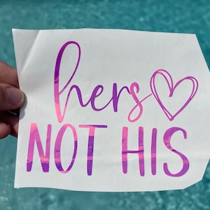 May include: A pink and purple vinyl sticker with the text "hers not his" and a pink heart.