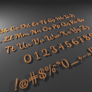 Könnte beinhalten: Obere und untere Buchstaben, Zahlen und Symbole aus Holz in einer Schreibschrift. Die Buchstaben und Zahlen sind in einem warmen, hellbraunen Farbton gehalten und auf einer dunkelgrauen Oberfläche angeordnet.