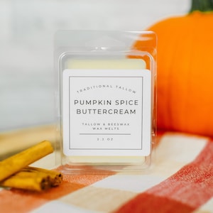 May include: A white wax melt in a clear plastic container with a label that reads "Traditional Tallow Pumpkin Spice Buttercream Tallow & Beeswax Wax Melts 2.2 oz".
