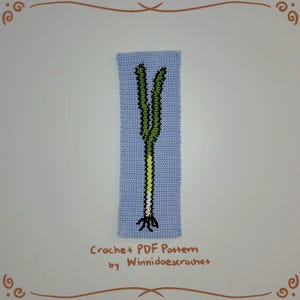 K&ouml;nnte beinhalten: Ein H&auml;kelmuster f&uuml;r einen gr&uuml;nen und wei&szlig;en Lauch, mit dem Text "Crochet + PDF Pattern by WinniDoescrochet" unten.