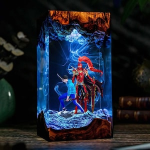 May include: A rectangular resin art piece featuring two warrior figures. One figure is clad in red armor, the other in blue. The resin has a blue and white ethereal design, encased in a wooden frame. The piece is illuminated from within.