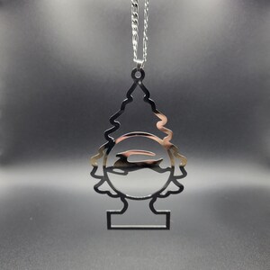 Peut inclure: Une décoration de Noël en argent en forme d'arbre avec une découpe d'un lapin à l'intérieur d'un cercle. L'ornement est suspendu à une chaîne en argent.
