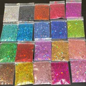 Puede incluir: Surtido de 18 pequeñas bolsas de purpurina iridiscente en varios colores, incluyendo plata, azul, verde, rojo, rosa y dorado. La purpurina está envasada en bolsas de plástico transparentes con cierre de cremallera.