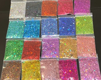 Puede incluir: Surtido de 18 pequeñas bolsas de purpurina iridiscente en varios colores, incluyendo plata, azul, verde, rojo, rosa y dorado. La purpurina está envasada en bolsas de plástico transparentes con cierre de cremallera.