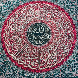 Könnte beinhalten: Ein Wandteppich mit einem kreisförmigen Design, das komplizierte arabische Kalligraphie in Weiß auf rotem Hintergrund zeigt. Die Kalligraphie ist von einem grünen Rand mit floralen Mustern umgeben.