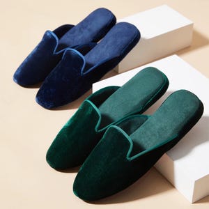 Puede incluir: Dos pares de zapatillas de terciopelo, un par es azul marino y el otro par es verde oscuro.