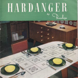 May include: Vintage magazine cover titled "HARDANGER by Penelope" in white text on a green background. The image shows a dining table set for four with a white tablecloth, green plates, and yellow bowls. A needlecraft publication.