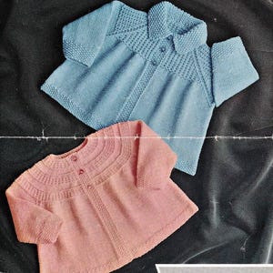 May include: Two knitted cardigans, one light blue with a collar and one pink with a round neckline, both featuring button closures and textured yoke detailing. The image includes the text Scotch Wool Shop 182 9d, Greenock, 4-ply, and 3 to 15 months.