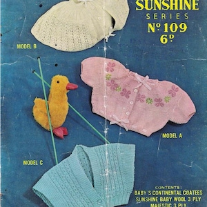 May include: Vintage knitting pattern cover featuring baby clothes. The cover displays three knitted garments: a cream-colored bonnet, a pink sweater with floral embroidery, and a blue cardigan. A yellow duck toy is also present. The text reads "Sirdar Sunshine Series No. 109".