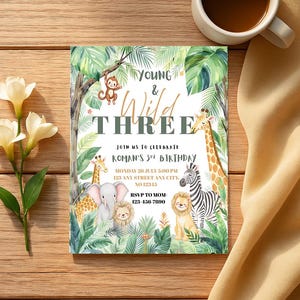 以下が含まれることがあります： ジャングルをテーマにした誕生日招待状。招待状には「Young & Wild Three」の文字と、猿、キリン、象、ライオン、シマウマのイラストが描かれています。招待状にはパーティーの詳細が含まれています。