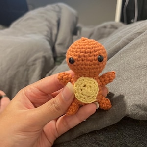 May include: A small crocheted orange and yellow turtle toy with black eyes.