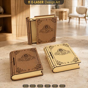 Può includere: Tre scatole rettangolari in legno a forma di libri vintage con angoli e bordi decorativi tagliati al laser. Ogni scatola presenta il testo E-LASER Design Art e un logo circolare sulla copertina anteriore. Due scatole sono posate in piano.