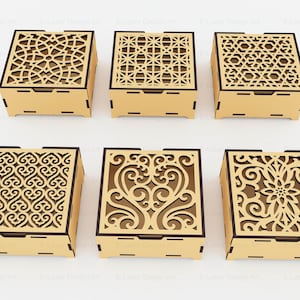 Puede incluir: Seis cajas cuadradas de madera con tapas cortadas a l&aacute;ser que presentan intrincados patrones geom&eacute;tricos y florales. Cada caja tiene un acabado en tono bronceado claro con bordes marr&oacute;n oscuro y recortes detallados en la parte superior.