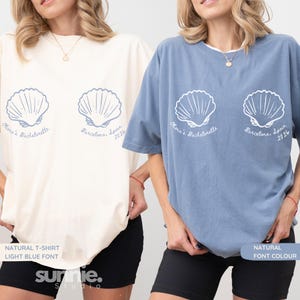 May include: Two t-shirts, one cream and one blue, each with a seashell design and the text "Olivia's Bachelorette, Barcelona, Spain 2026." The cream shirt has light blue font, and the blue shirt has natural font colour. The brand name "sunnie. studio" is at the bottom.
