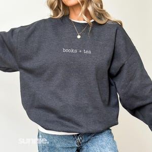 May include: A dark grey sweatshirt with the text "books + tea" embroidered on the front.