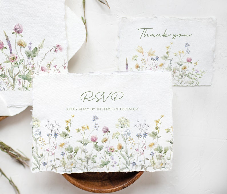 May include: Three white cards with a watercolor floral design and green text. The top card says "Thank you". The middle card says "RSVP" and "Kindly reply by the first of December". The bottom card has a floral design.