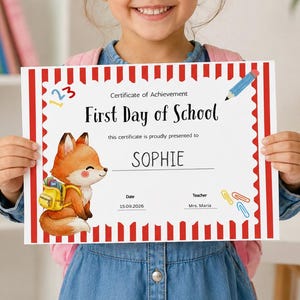 May include: A white certificate of achievement for the first day of school with a red and white striped border. It features a cartoon fox wearing a yellow backpack, a blue pencil, and paperclips. The text reads First Day of School and SOPHIE.