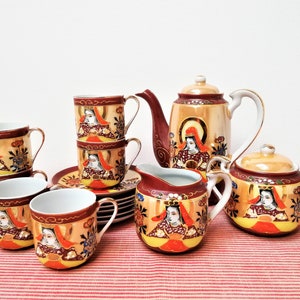 May include: A vintage Japanese tea set with a gold and red floral design. The set includes a teapot, creamer, sugar bowl, and four cups and saucers.
