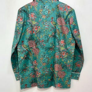 My Include : A Green Floral Patterned Night suit (Pyjama set) A Long Sleeve Shirt and Matching Pants. The Shirt Has a Pocket with White Piping.