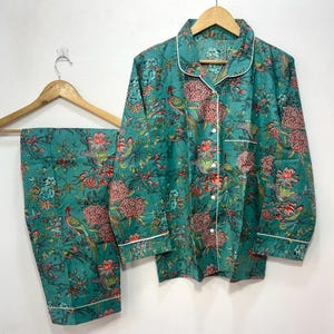 My Include : A Green Floral Patterned Night suit (Pyjama set) A Long Sleeve Shirt and Matching Pants. The Shirt Has a Pocket with White Piping.